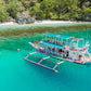 Keelooma outrigger boat with crew, deck cushions and a kayak on board,  on an El Nido island hopping tour