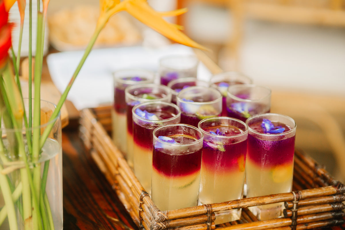 Welcome drinks of lemongrass, calamansi and blue ternate, grown at Kaseledan Farm, served in tall glasses on a bamboo tray, El Nido, Palawan