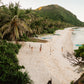 A palm-fringed beach with outrigger boats and a Keelooma camp along the shoreline, seen from above, Palawan