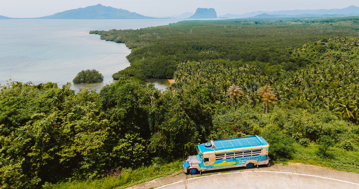 Keelooma's jeepney on a coastal ridge road above the mangroves at Sibaltan, El Nido, Palawan, with limestone cliffs on the horizon