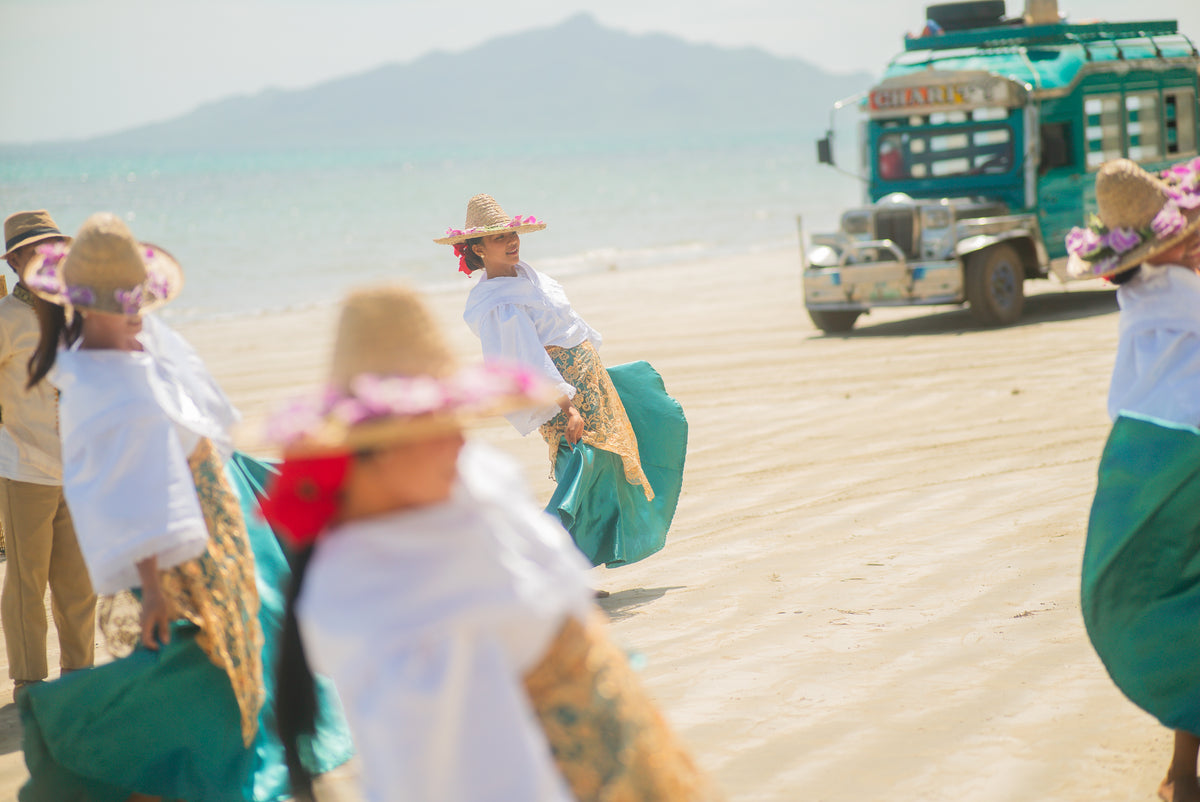 Dancers from the Keelooma Cultural Dance Troupe performing on the beach at Ursula Beach Club, with the Keelooma jeepney behind, Sibaltan, El Nido, Palawan